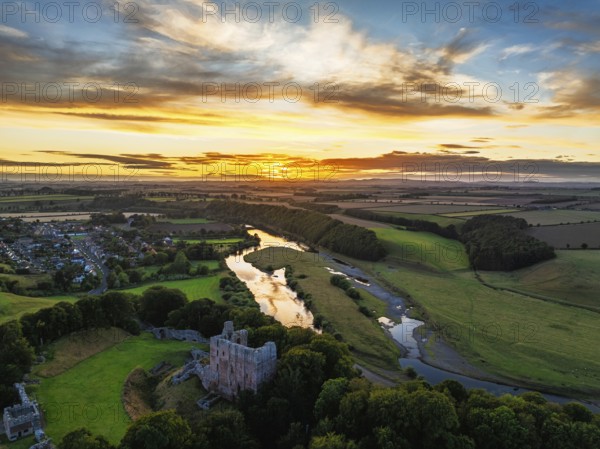Sunset over Norham Castle and River Tweed from a drone, Norham, Northumberland, England, United Kingdom
