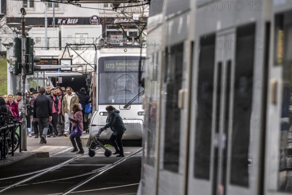 Pedestrians cross the tram tracks, at Düsseldorf-Bilk station, junction of S-Bahn, subway, tram, local bus transport, North Rhine-Westphalia