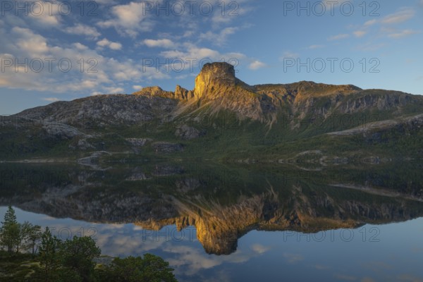 Morning dream over the quiet Steigtindvatnet near Bodø. Pine forest on the rock face at sunrise