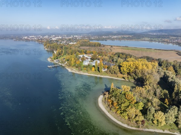 Aerial view of the Mettnau peninsula, surrounded by autumn vegetation, in western Lake Constance with the spa center, Mettnaukur, boat dock and restaurant Strandcafe, Radolfzell, Konstanz district, Baden-Württemberg, Germany