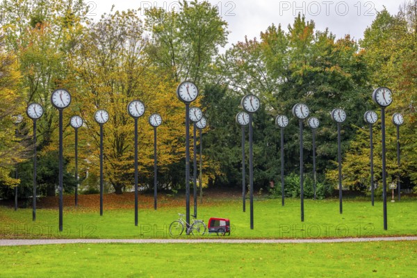 The art installation Zeitfeld in Volksgarten Park in Düsseldorf-Oberbilk, a total of 24 station clocks, on 6 meter high steel columns, have been running synchronously since 1987, artwork by Düsseldorf artist Klaus Rinke, symbol of time, time change, North Rhine-Westphalia, Germany