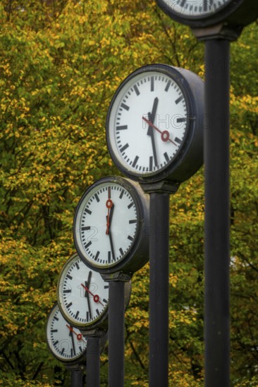 The art installation Zeitfeld in Volksgarten Park in Düsseldorf-Oberbilk, a total of 24 station clocks, on 6 meter high steel columns, have been running synchronously since 1987, artwork by Düsseldorf artist Klaus Rinke, symbol of time, time change, North Rhine-Westphalia, Germany