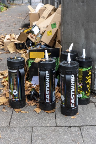 Empty cartridges filled with N2O, nitrous oxide gas, called laughing gas, officially it serves as a propellant to produce whipped cream in appropriate devices, but is often used as an intoxicant, party drug, misused, here mass, illegal disposal in addition to waste paper containers in Düsseldorf, North Rhine-Westphalia, Germany