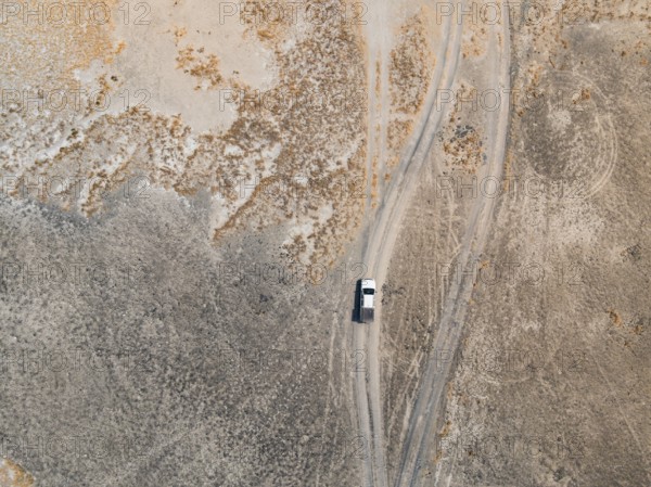 Aerial view, top-down view, off-road car driving on a salt pan, arid landscape, Botswana