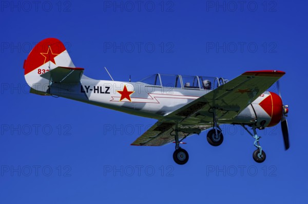 A Jakovlev Jak-52 with registration LY-HLZ during a flight demonstration as part of an air show on Rossfeld in Metzingen-Glems, Baden-Württemberg, Germany, for editorial use only
