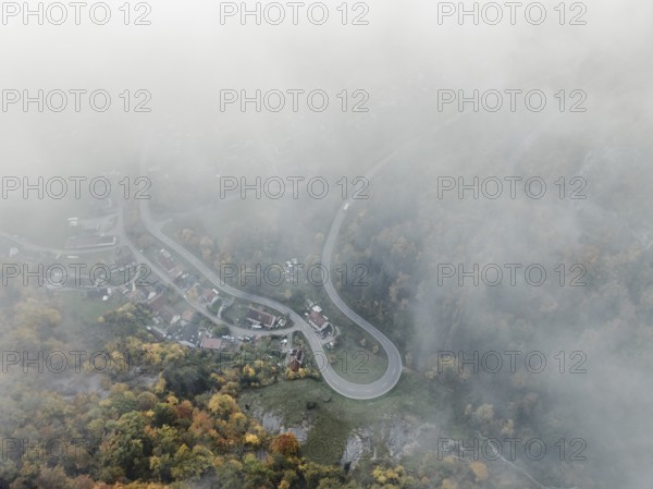 Aerial view of the viewpoint, shovels and Hausen Castle, also known as the Hausen ruins, surrounded by autumnal vegetation and clouds of fog on the village of Hausen in the valley in the Upper Danube Valley, Beuron, Sigmaringen district, Baden-Württemberg, Germany