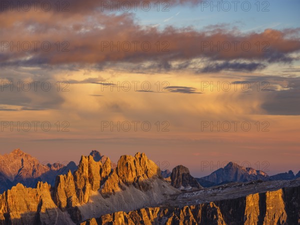 Alpine glow, rugged Dolomite peaks at sunset, colored clouds above, Dolomites, Alps, Belluno province, Veneto region, Veneto, Italy