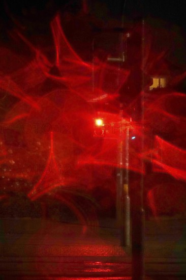 Traffic light, road traffic at night and poor visibility in a city, autumn, Germany