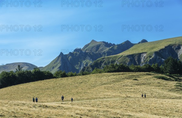 Auvergne Volcanoes Regional Park. Groups of hikers traverse a rugged path in the beautiful Sancy Massif region, Puy de Dome, Auvergne, France