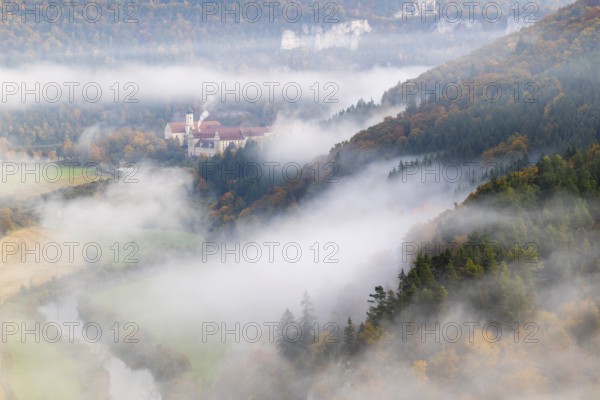View of Benedictine monastery Beuron, Archabbey of St. Martin, limestone rock, rock face, mixed forest, autumn colours, fog, autumn, Fridingen, Danube Valley, Upper Danube nature park Park, Baden-Württemberg, Germany