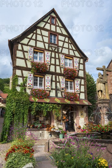 Emperor Constantin fountain in front of a half-timbered house in Kaysersberg