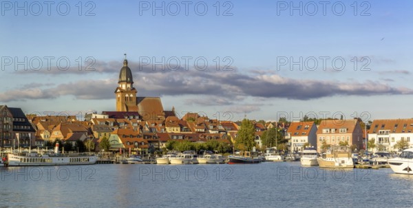 Panoramic view of the city of Waren (Müritz) with a view of the harbor from the water in sunny weather with blue skies and light cloud cover, Waren, Mecklenburg-Vorpommern, Germany