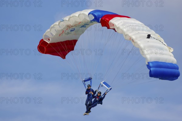 Two parachutists during an aerial acrobatic performance as part of an air show at the Rossfeld in Metzingen-Glems, Baden-Württemberg, Germany, for editorial use only