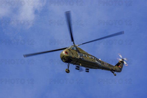 A Sikorsky S-58C transport helicopter in the colours of the German Army with the registration D-HAUG during a flight demonstration as part of an air show at the Rossfeld in Metzingen-Glems, Baden-Württemberg, Germany, for editorial use only