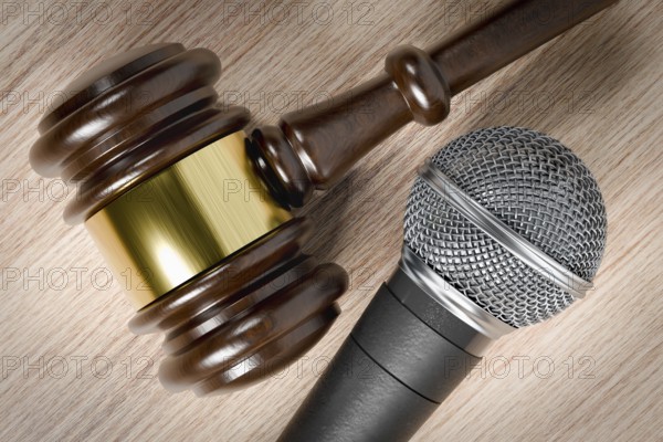 Close-up of a gavel and microphone resting on a wooden table