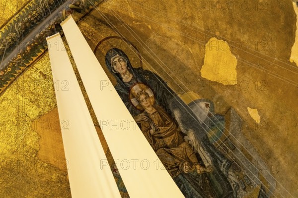 Mosaic with the Madonna and Child partially covered with fabric in the apse of the present-day mosque Hagia Sophia or Church of St Sophia, former Byzantine church and museum in Istanbul, Turkey