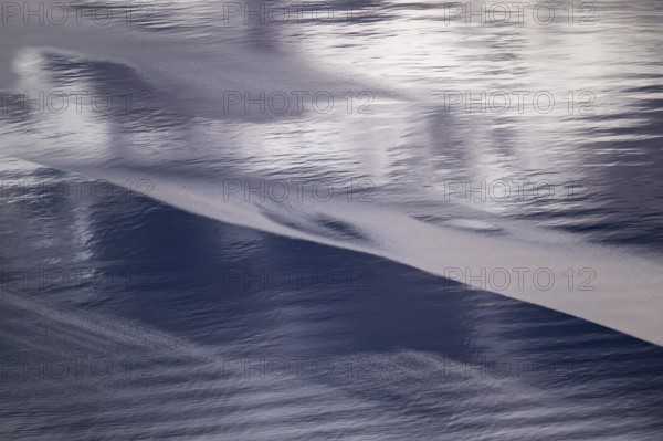 Light and shadow on gentle waves form structures on the sea surface in a bay, Otroya or Otrøya island, Møre og Romsdal, Norway