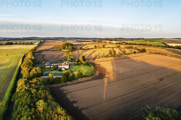 Sunset of Farms and Fields over Norham Castle from a drone, Norham, River Tweed, Northumberland, England, United Kingdom