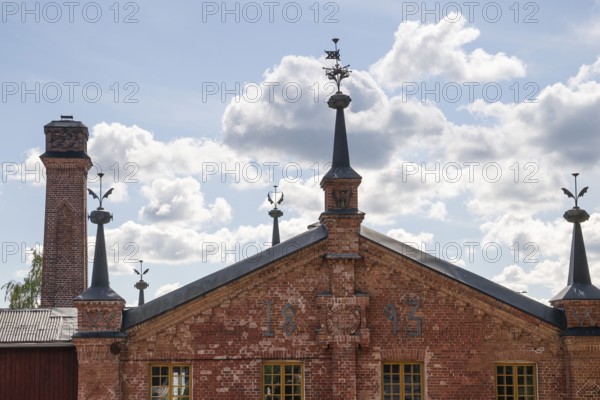 Brick building with weather vane and chimney, former paper mill for the production of groundwood pulp board, UNESCO World Heritage Site Factory Village Verla, Maailmanperintökohde Verlan puuhiomo ja pahvitehdas, Verla Rapids, Kymenlaakso, near Kouvola, Finland