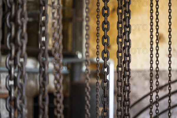 Hanging iron chains in various sizes, factory hall with machines for the production of cardboard and paper, former paper factory and mill for the production of groundwood pulp board, UNESCO World Heritage Site Verla Factory Village, Maailmanperintökohde Verlan puuhiomo ja pahvitehdas, Verla Rapids, Kymenlaakso, near Kouvola, Finland