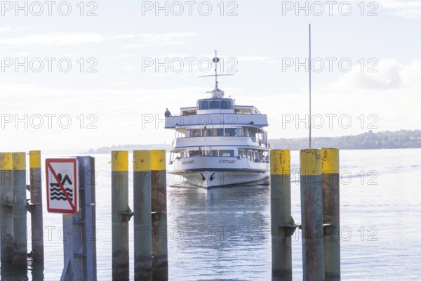 Ferry approaching the pier over a calm lake under a clear sky, Überlingen, Lake Constance, Germany