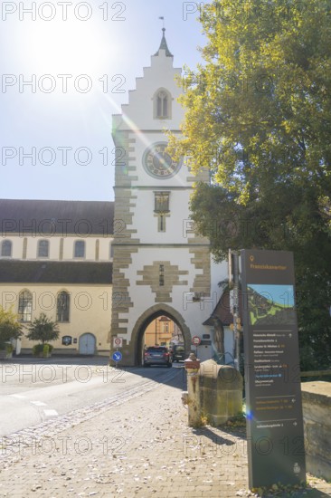 Historic town gate with church tower in the sunshine on an autumnal street, Überlingen, Lake Constance, Germany