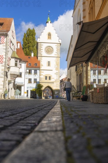 View through an alley to a historic Tor tor under a blue sky with clouds, Überlingen, Lake Constance, Germany