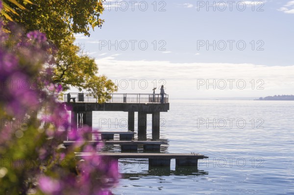 Footbridge at the water with people and autumn coloured trees in the background, Überlingen, Lake Constance, Germany