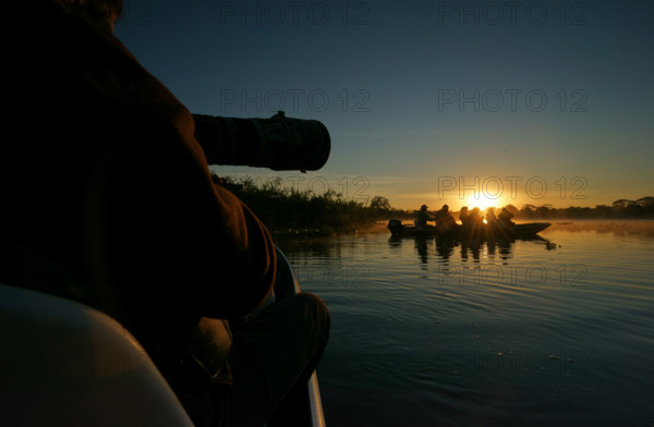 Wildlife photographers in a boat on a river in the Pantanal, Brazil