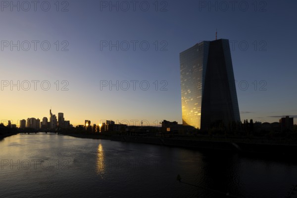 The light of the setting sun is reflected in the glass façade of the Frankfurt banking skyline, Frankfurt am Main, Hesse, Germany