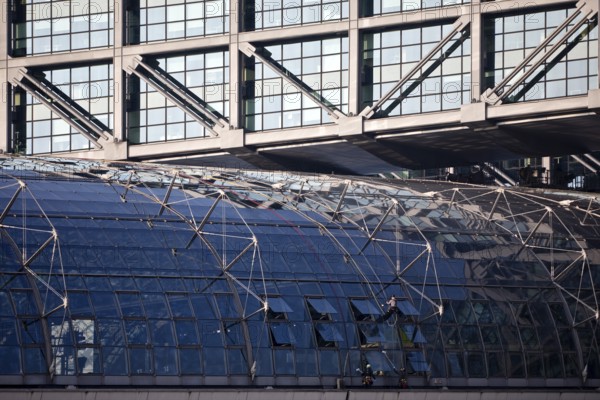 Three male glass cleaners cleaning a glass roof at Berlin Central Station, Berlin, Germany