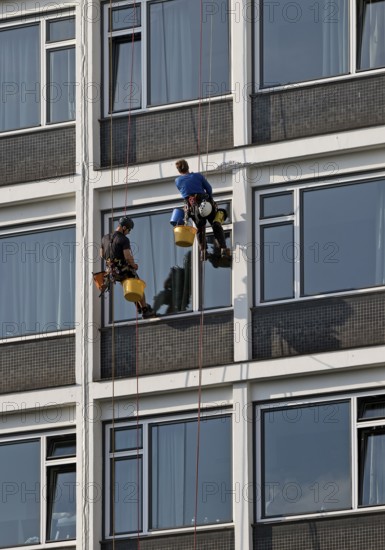 Two male glass cleaners abseiling down the hotel façade to clean windows, aletto Hotel Kudamm, Berlin, Germany