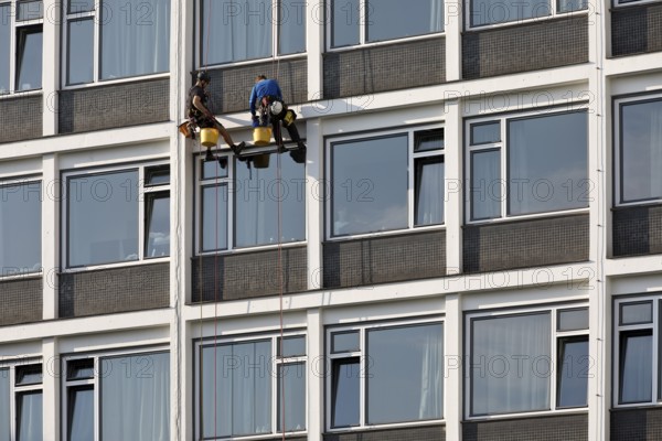 Two male glass cleaners abseiling down the hotel façade to clean windows, aletto Hotel Kudamm, Berlin, Germany