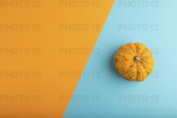 Orange Pumpkin on orange and blue pastel paper background. Top view, copy space, flat lay. healthy food, vegetable, minimalism