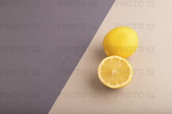 Yellow Lemon Cut in half on beige and gray pastel paper background. Side view, copy space. healthy food, vegetable, minimalism