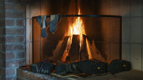 Cosy fireplace with fire to dry wet socks and shoes, hostel on the Olavsweg or Olavsleden pilgrimage route, Norway