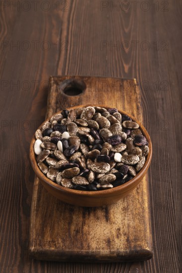 Wooden bowl with Kidney beans on brown wooden background, side view, copy space, minimalism