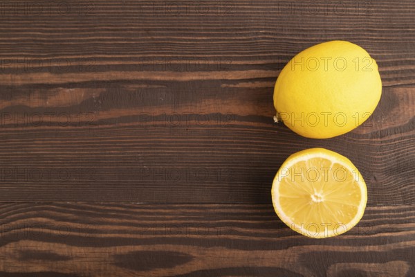 Yellow Lemon Cut in half on brown wooden background. Top view, flat lay, copy space. healthy food, vegetable, minimalism. citrus