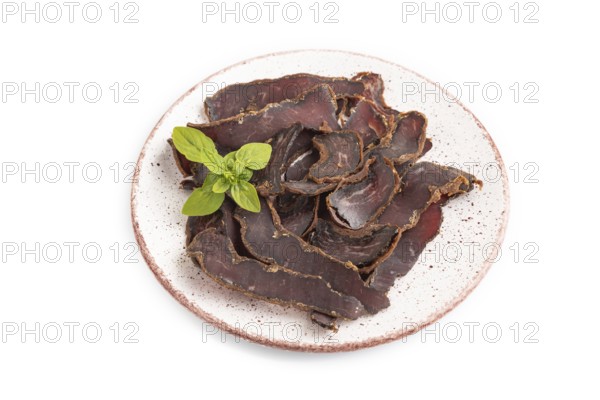Armenian Basturma dried meat on plate with pepper and herbs isolated on white background. Side view