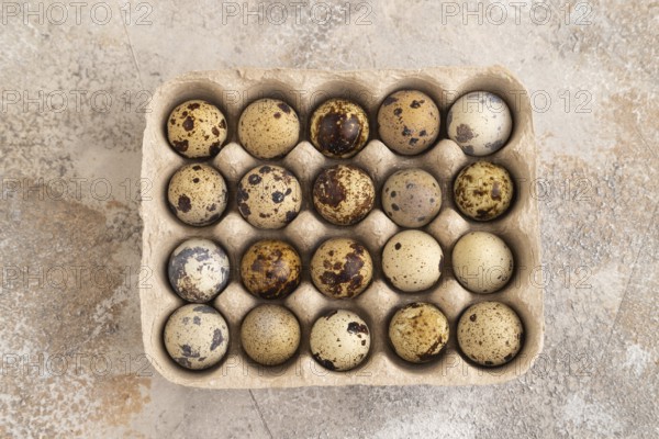 Pile of Raw Quail eggs on a brown concrete background. top view, flat lay, close up