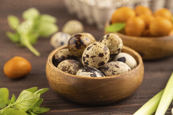 Pile of Smoked Quail eggs in bowl on a brown wooden background. side view, close up, selective focus