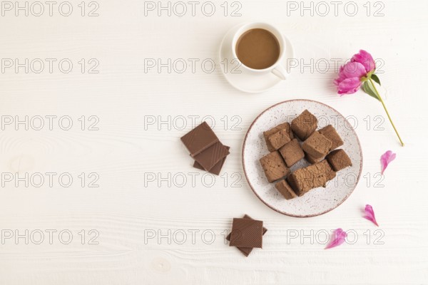 Chocolate marshmallow with cup of coffee on white wooden background. top view, flat lay, copy space