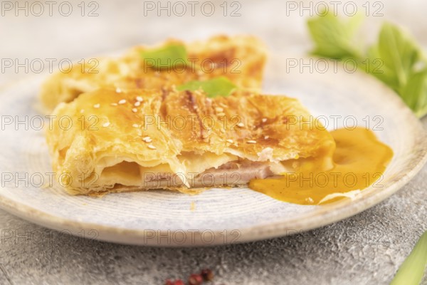 Fried homemade Khachapuri cake with cheese and meat, fried in pan. Traditional Georgian cuisine on brown concrete background. Side view, close up, selective focus