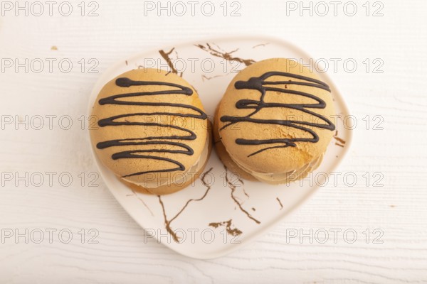 Caramel Cream Cakes on white wooden background, top view, flat lay, close up
