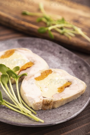 Chicken, egg and dried apricot meatloaf, microgreen on brown wooden. Diet, healthy eating. side view, selective focus