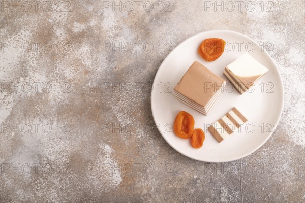 Cocoa and milk jelly with dried apricots on brown concrete background, top view, flat lay, copy space, minimalism