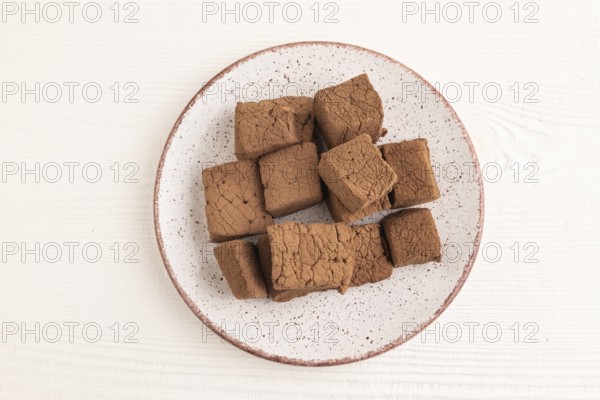 Chocolate marshmallow on white wooden background. top view, flat lay, close up