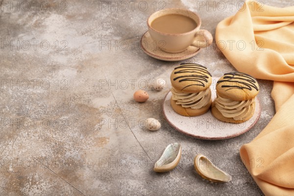 Caramel Cream Cakes on brown concrete background, cup of coffee, side view, copy space