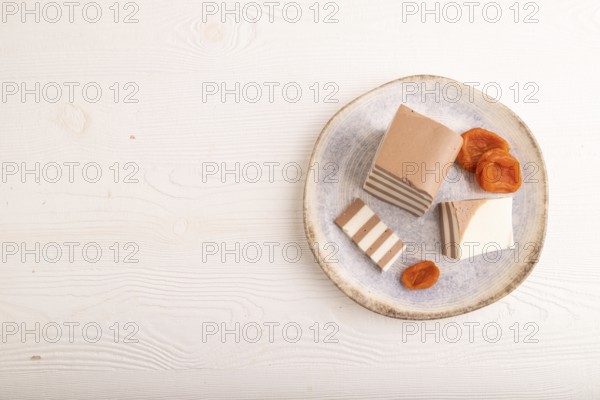 Cocoa and milk jelly with dried apricots on white wooden background, top view, flat lay, copy space, minimalism