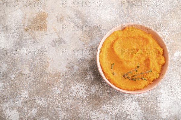 Sweet potato porridge in ceramic bowl on brown concrete background. Diet, healthy eating concept. top view, flat lay, copy space